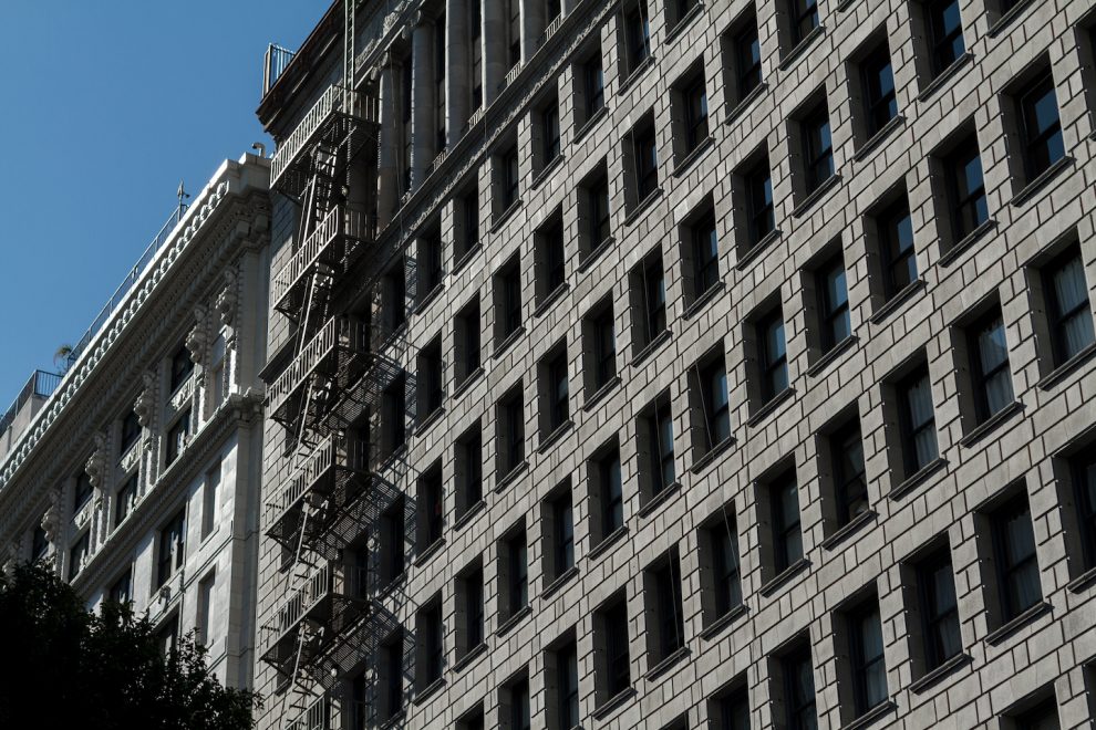 Sunlight reflecting off of a beautiful ornate turn of the 20th century building with a fire escape in Los Angeles, California.