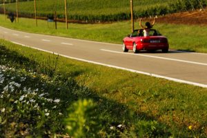 Bride And Groom Driving Away In convertible car