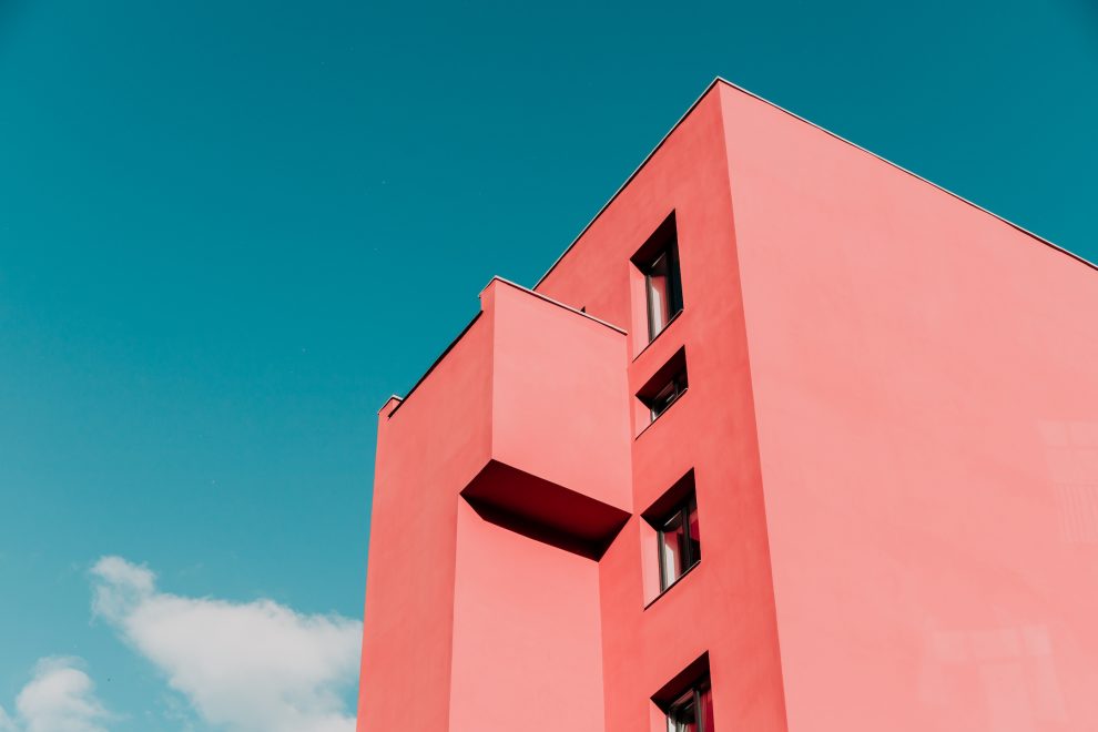View from below on a pink modern house and sky. Vintage pastel colors, minimalist concept.