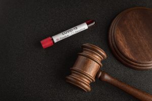 Judges gavel or mallet law and infected blood sample in sample tube COVID 19.